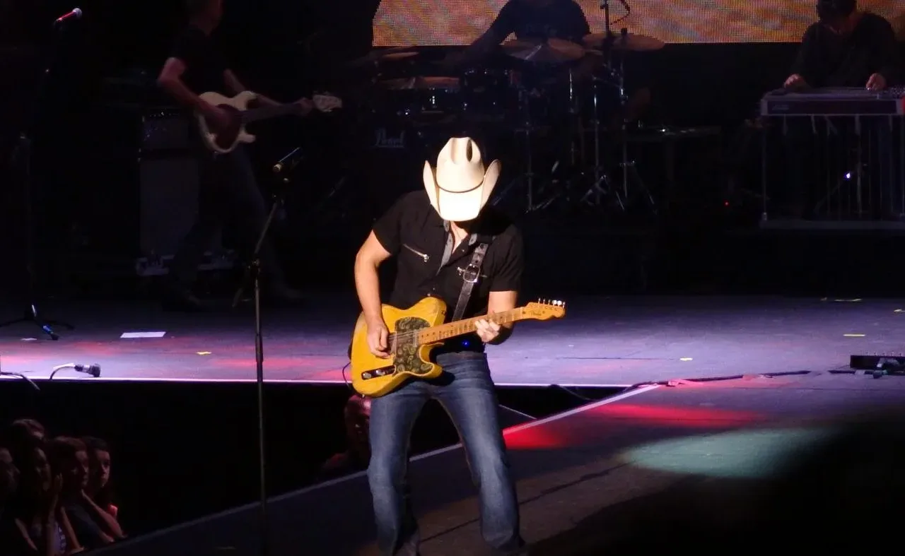 Brad Paisley wearing a cowboy hat and playing guitar onstage in Dublin