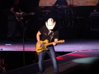 Brad Paisley wearing a cowboy hat and playing guitar onstage in Dublin