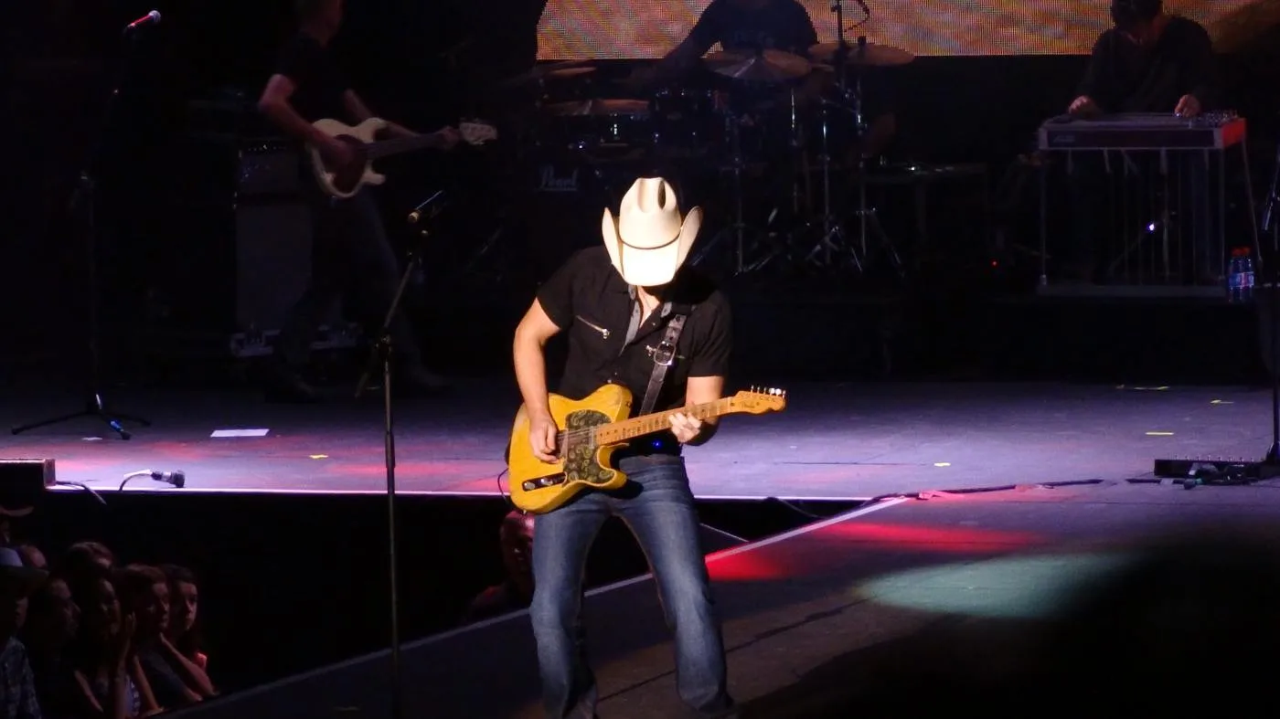 Brad Paisley wearing a cowboy hat and playing guitar onstage in Dublin