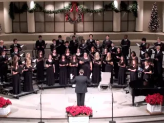 University of Arkansas Schola Cantorum choir sings together with a conductor in December 2012.