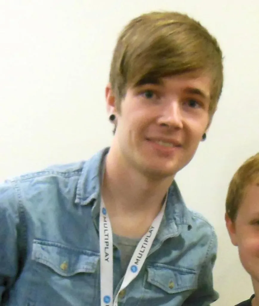 DanTDM at a convention in 2014 wearing a blue shirt and event lanyard