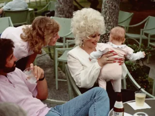 Dolly Parton pictured with visitors in Honolulu in an archive photograph from 1983