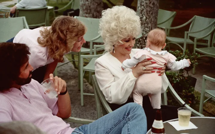 Dolly Parton pictured with visitors in Honolulu in an archive photograph from 1983