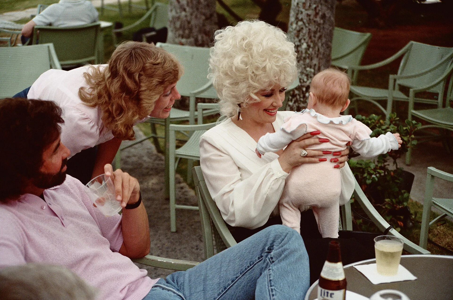 Open the featured image for Dolly Parton Net Worth: The Business Behind Her Legacy Dolly Parton pictured with visitors in Honolulu in an archive photograph from 1983