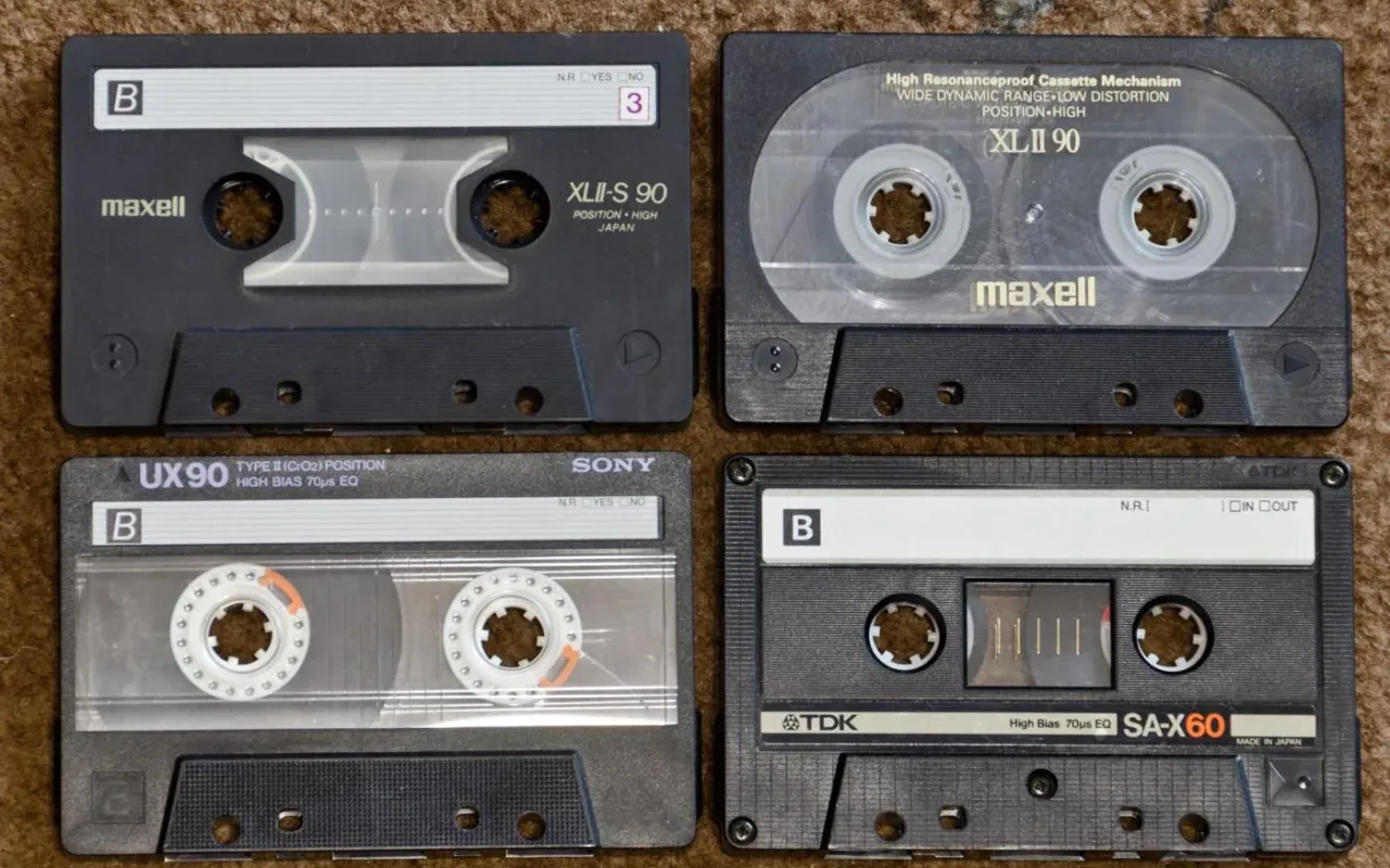 Four compact audio cassettes showing their labels and tape reels