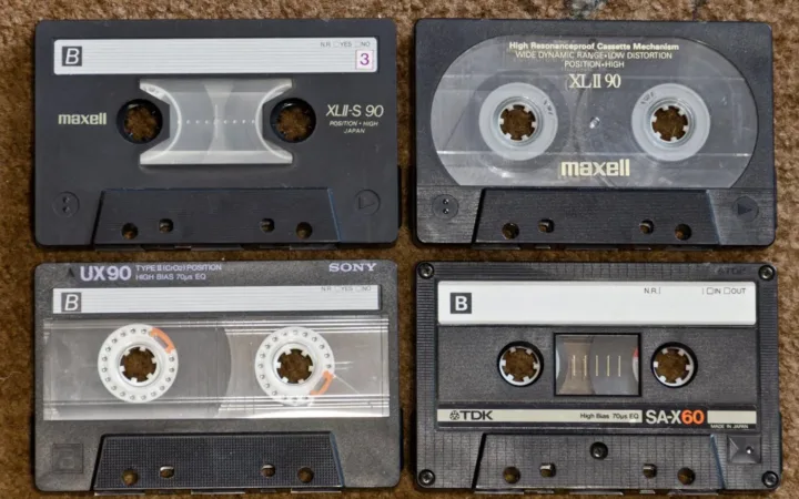 Four compact audio cassettes showing their labels and tape reels