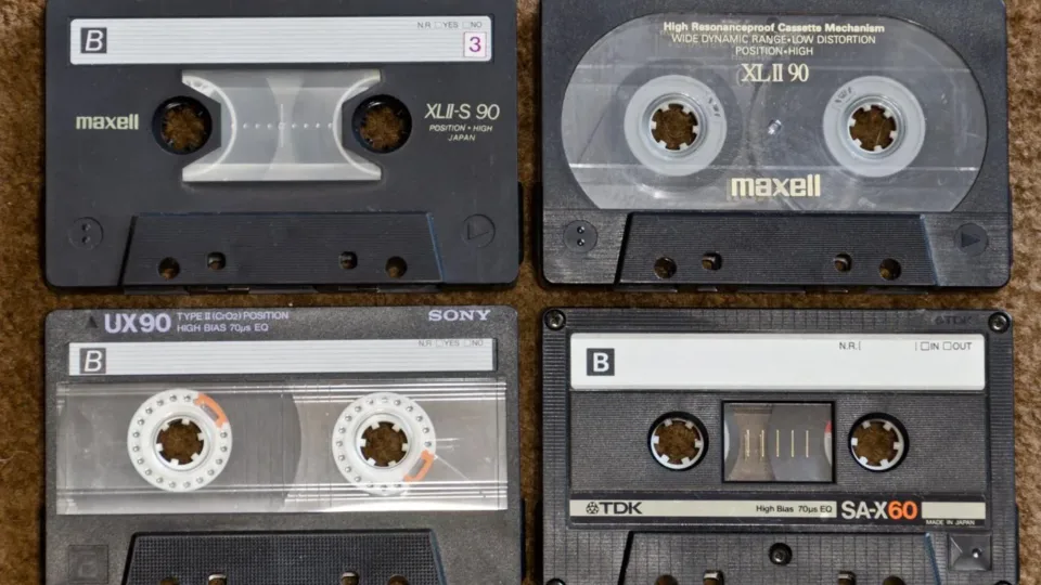 Four compact audio cassettes showing their labels and tape reels