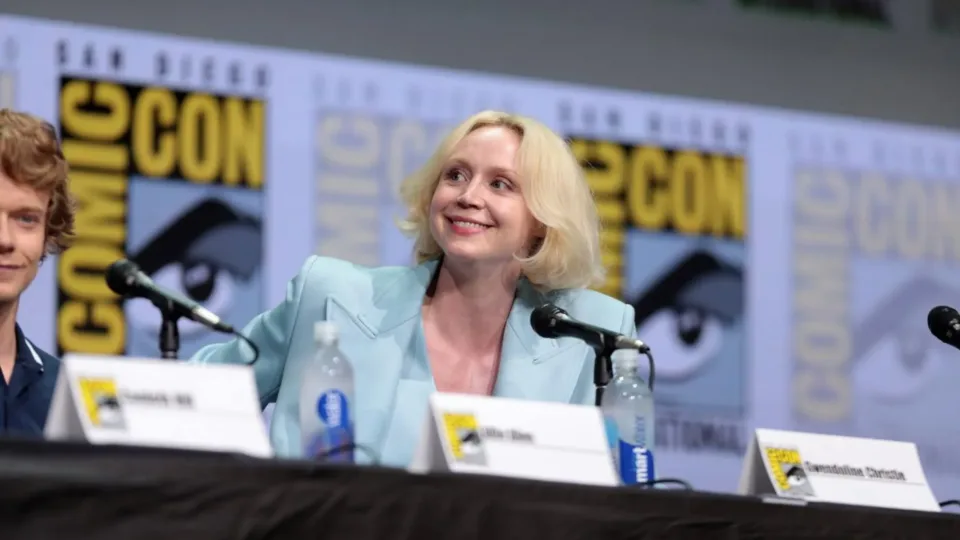 Gwendoline Christie seated at a Comic-Con panel in a pale blue jacket in 2017
