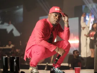 Olamide crouching onstage during his 2014 OLIC concert