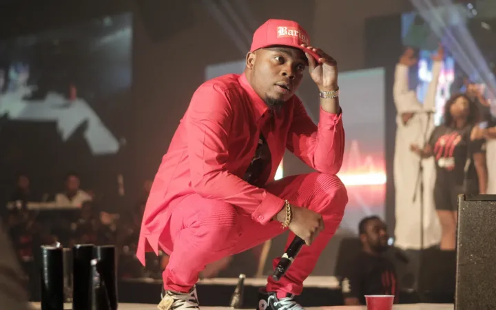 Olamide crouching onstage during his 2014 OLIC concert