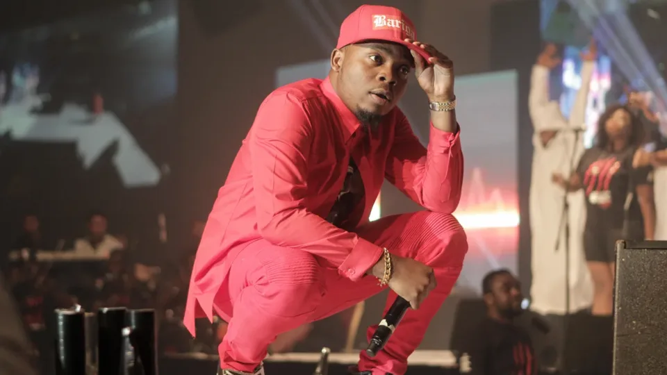 Olamide crouching onstage during his 2014 OLIC concert