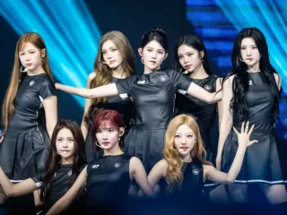 The eight members of Hearts2Hearts pose together onstage at a 2026 fan event.
