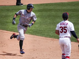Ichiro Suzuki in a Miami uniform rounding third base while Greg Garcia watches in St Louis in 2016