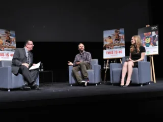 Judd Apatow seated between Richard Crouse and Leslie Mann at a 2012 comedy discussion