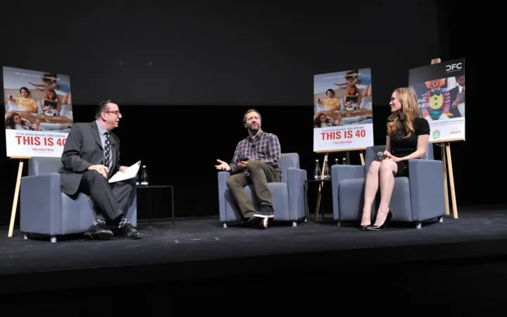 Judd Apatow seated between Richard Crouse and Leslie Mann at a 2012 comedy discussion