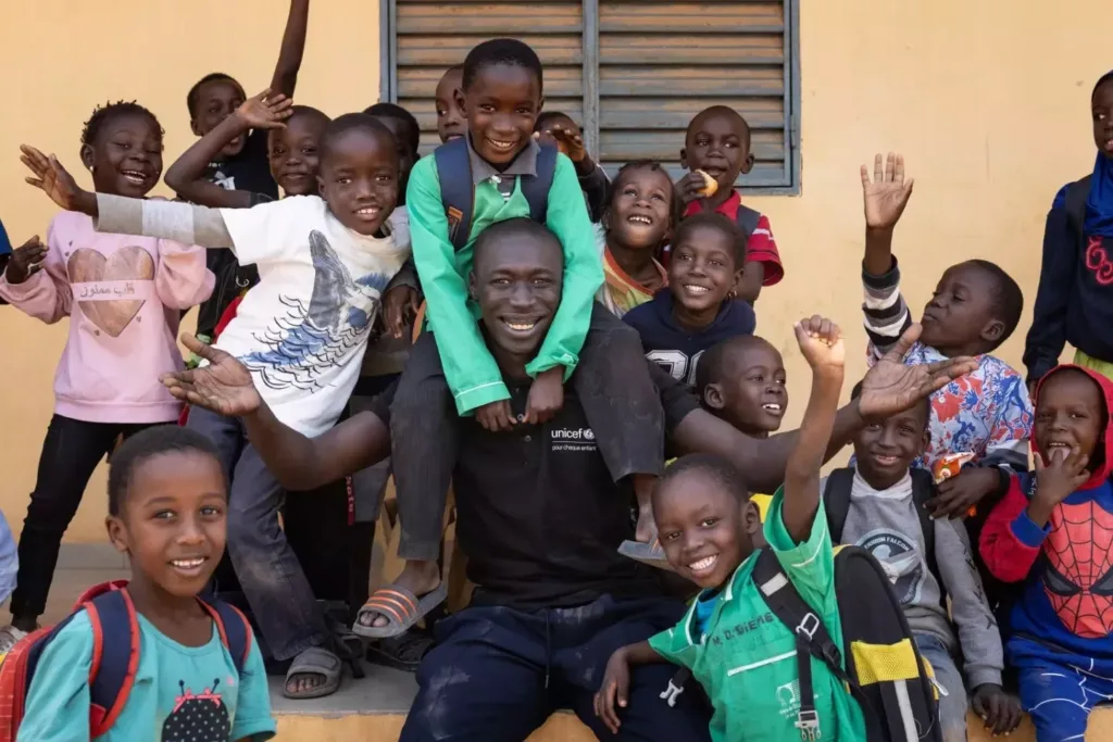 Khaby Lame sits with smiling students during his January 2025 school visit in Ziguinchor, Senegal.