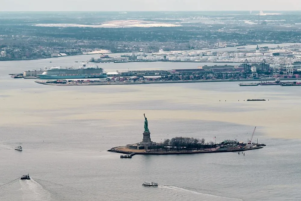 An aerial view of Liberty Island with ferries crossing the surrounding harbour