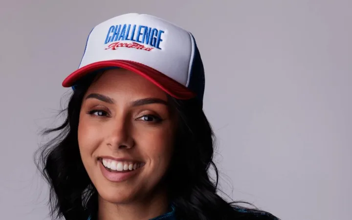 Michelle Khare wearing a Challenge Accepted cap and a blue jacket