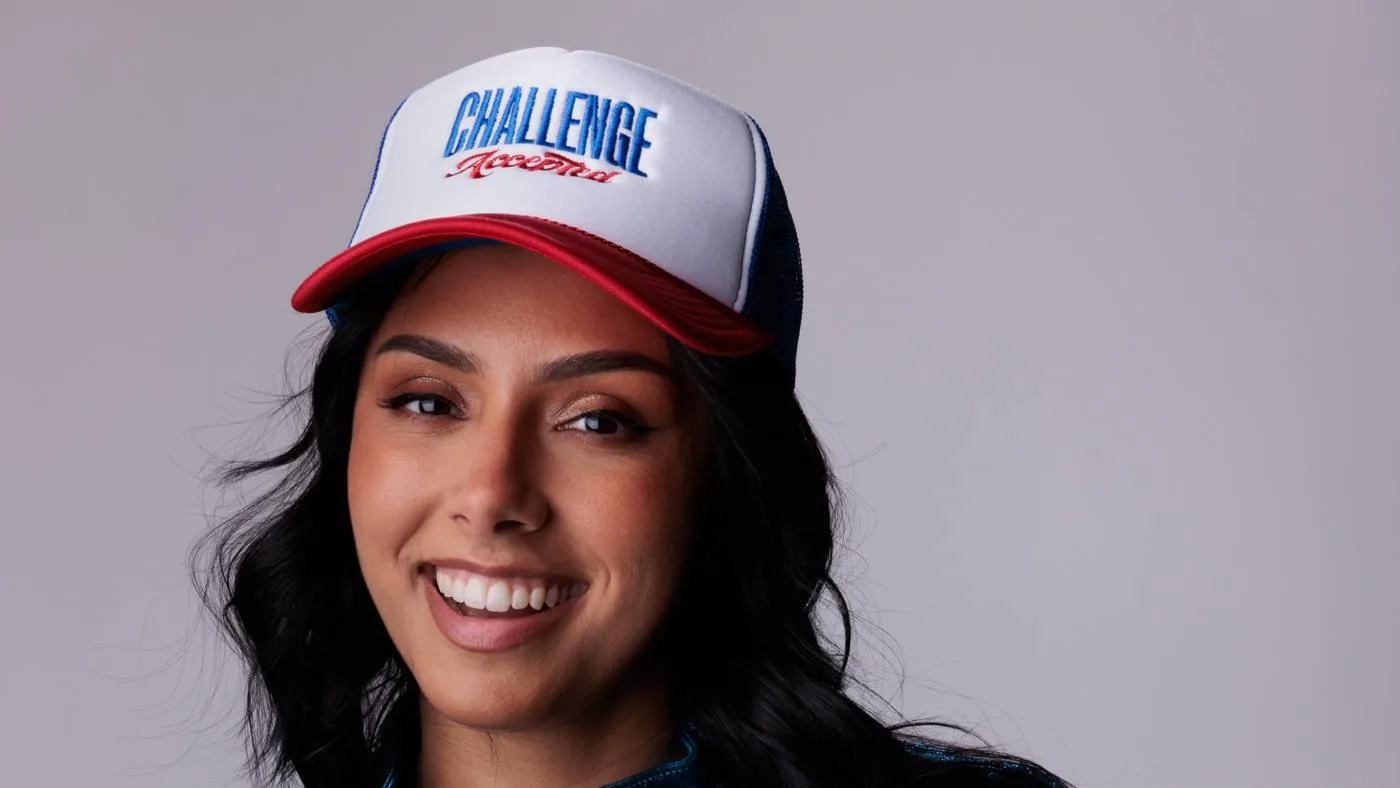 Michelle Khare wearing a Challenge Accepted cap and a blue jacket