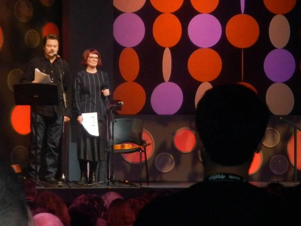 Nick Offerman and Megan Mullally standing together at microphones during the 2014 Sundance awards ceremony