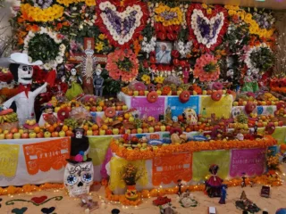 A Día de Muertos ofrenda in Milpa Alta with flowers, photographs, fruit and decorated paper
