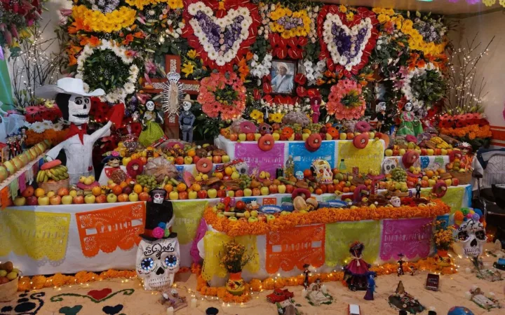 A Día de Muertos ofrenda in Milpa Alta with flowers, photographs, fruit and decorated paper