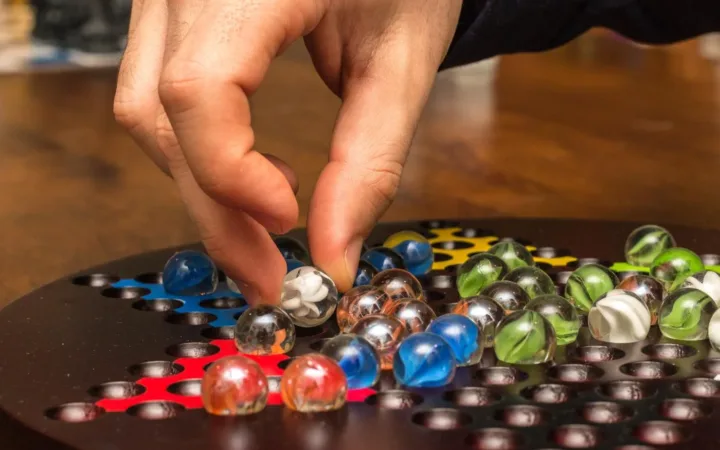 A player moving a glass marble during a board game night