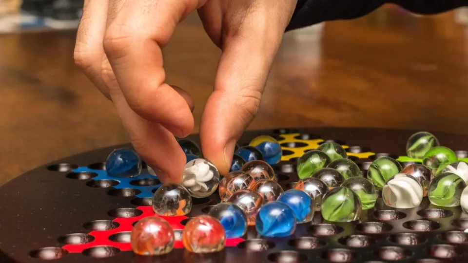 A player moving a glass marble during a board game night