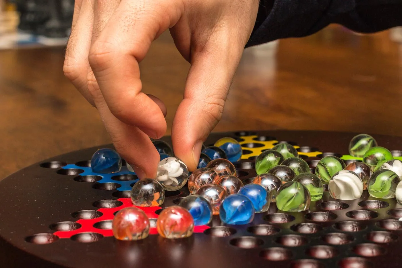 A player moving a glass marble during a board game night