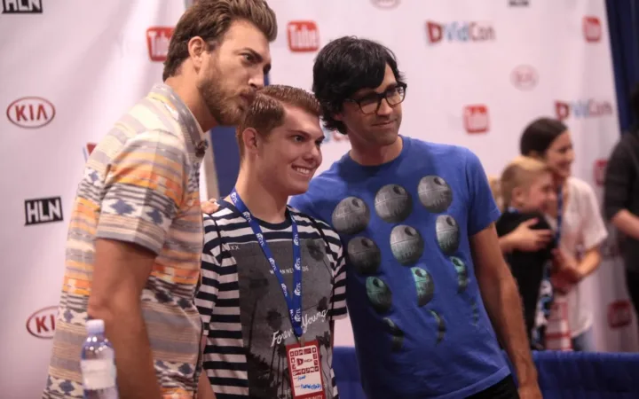 Rhett McLaughlin at left and Link Neal at right posing with an attendee at VidCon 2014