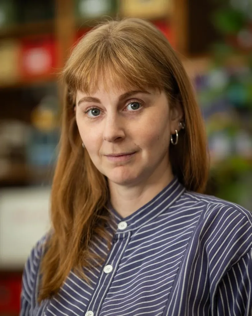 Portrait of Simone Giertz wearing a blue striped shirt in her studio