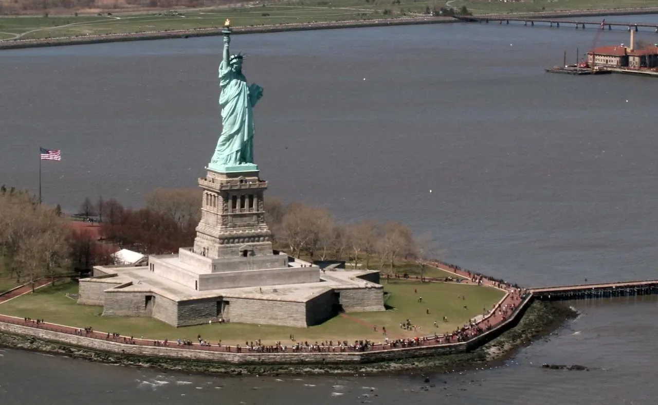 The Statue of Liberty on Liberty Island surrounded by New York Harbor