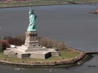 The Statue of Liberty on Liberty Island surrounded by New York Harbor