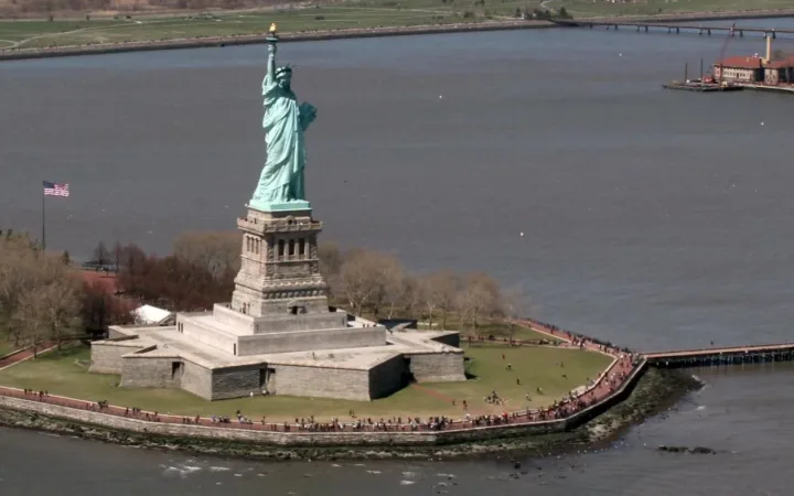 The Statue of Liberty on Liberty Island surrounded by New York Harbor