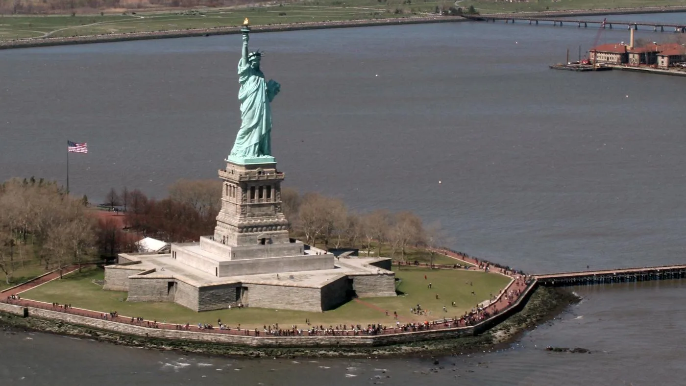 Open the featured image for Statue of Liberty at 140: The History Behind the Harbour Icon The Statue of Liberty on Liberty Island surrounded by New York Harbor