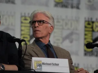 Ted Danson seated at a microphone during The Good Place panel at Comic-Con in 2018