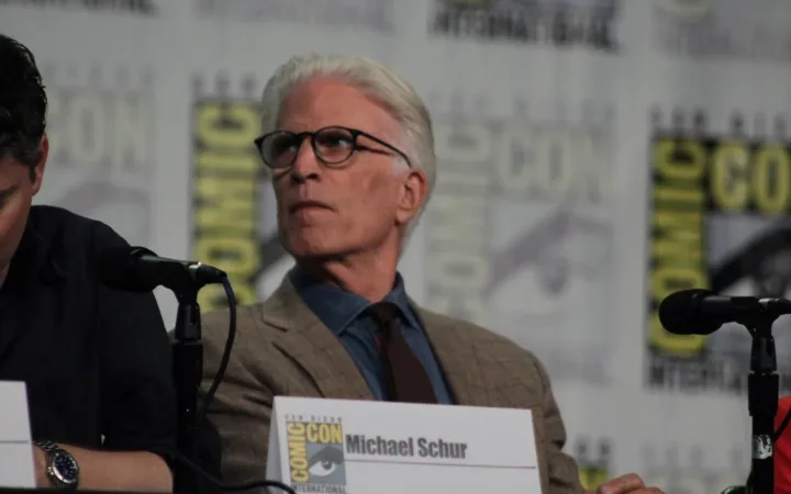 Ted Danson seated at a microphone during The Good Place panel at Comic-Con in 2018
