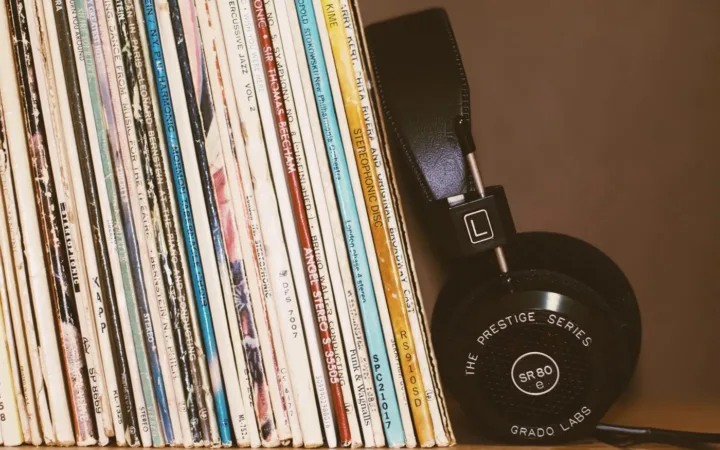 A row of sleeved vinyl records with headphones resting alongside them