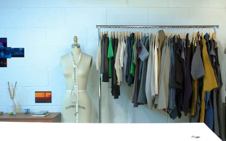 Clothes arranged on a rail with wooden hangers