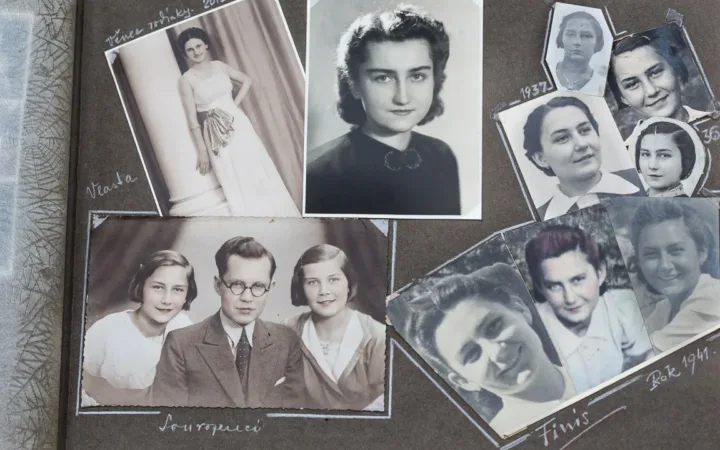 An open historical family photograph album with handwritten captions